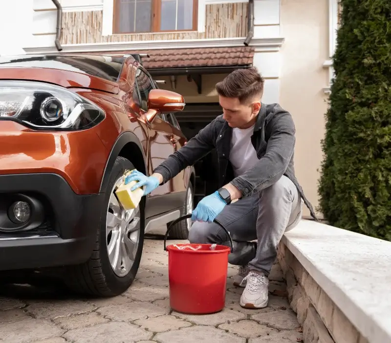 Lavage auto à domicile Ménilles : professionnel intervenant sur un véhicule